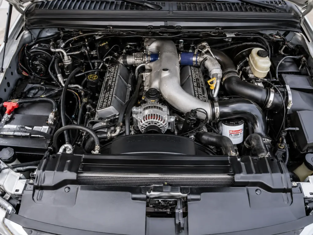 Overhead view of a 7.3 Powerstroke engine bay in a Ford Super Duty with valve covers and Motorcraft FL-1995 oil filter visible.