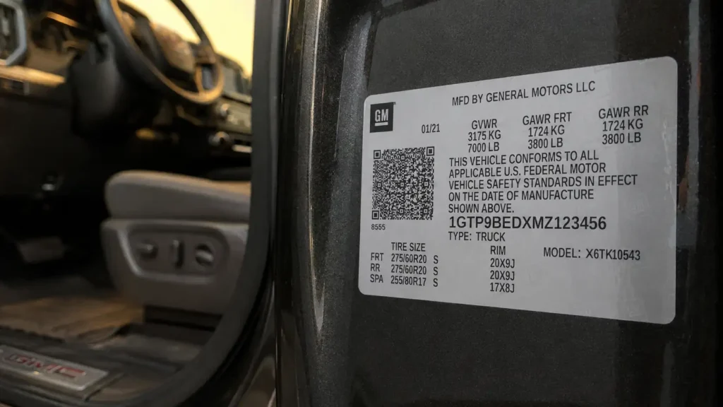 Close-up of GMC Sierra 1500 driver-side door jamb sticker showing GVWR and GAWR label details