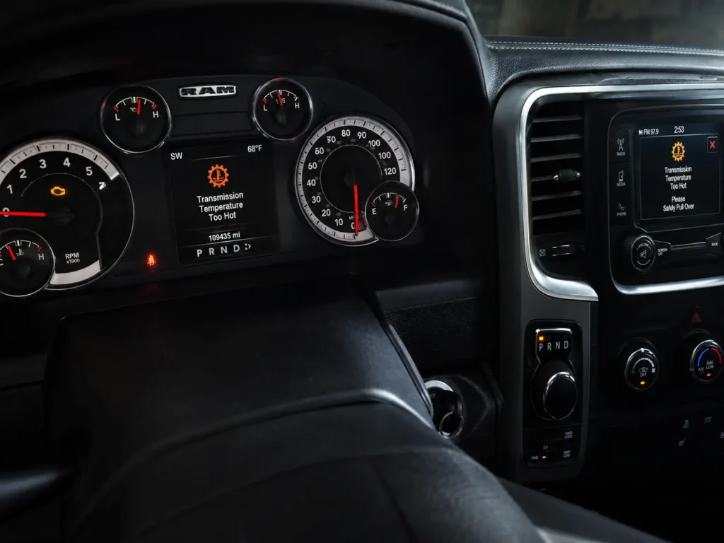 2017 Ram 1500 dashboard with the check engine light on and a transmission temperature warning displayed on the instrument cluster and center screen.