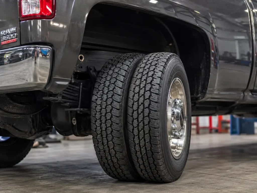 Ram 3500 dually rear wheel well showing narrow dual all-terrain tires and 8-lug hub