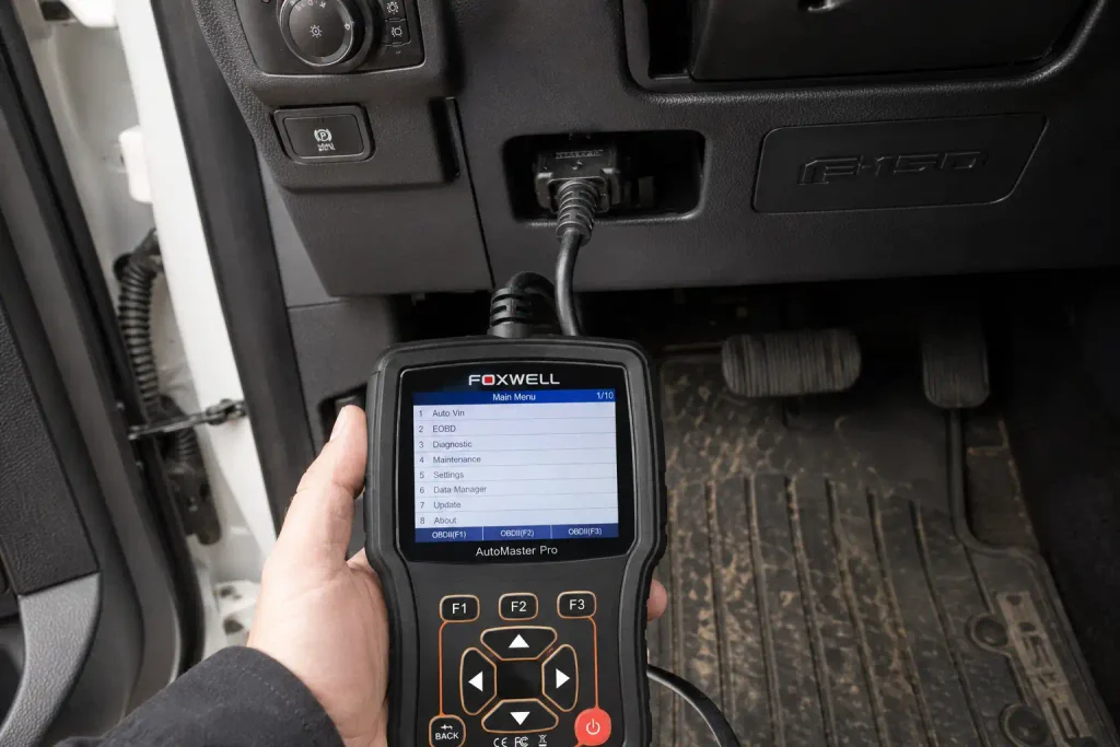 OBD2 scanner connected to Ford F150 diagnostic port for oil reset